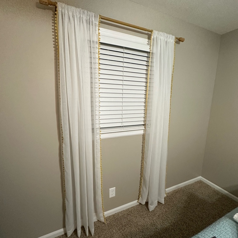 Sheer curtains with yellow Pom fringe.